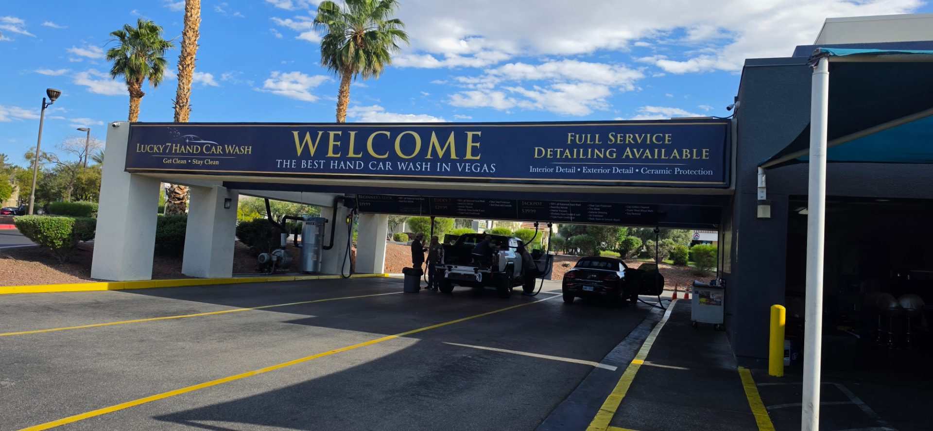 Vehicles being hand washed under the Lucky 7 Hand Car Wash package menu board