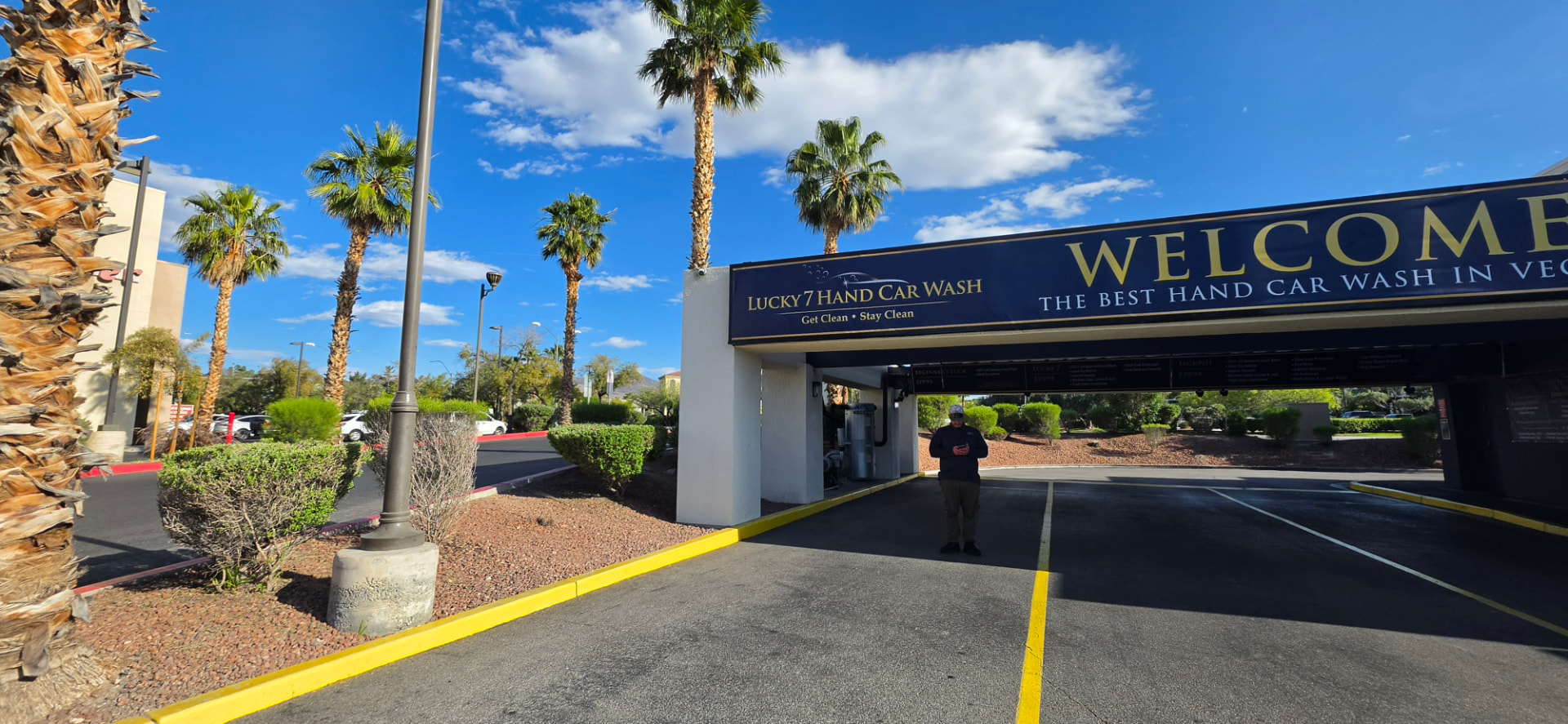 Palm-lined driveway leading into Lucky 7 Hand Car Wash in Henderson